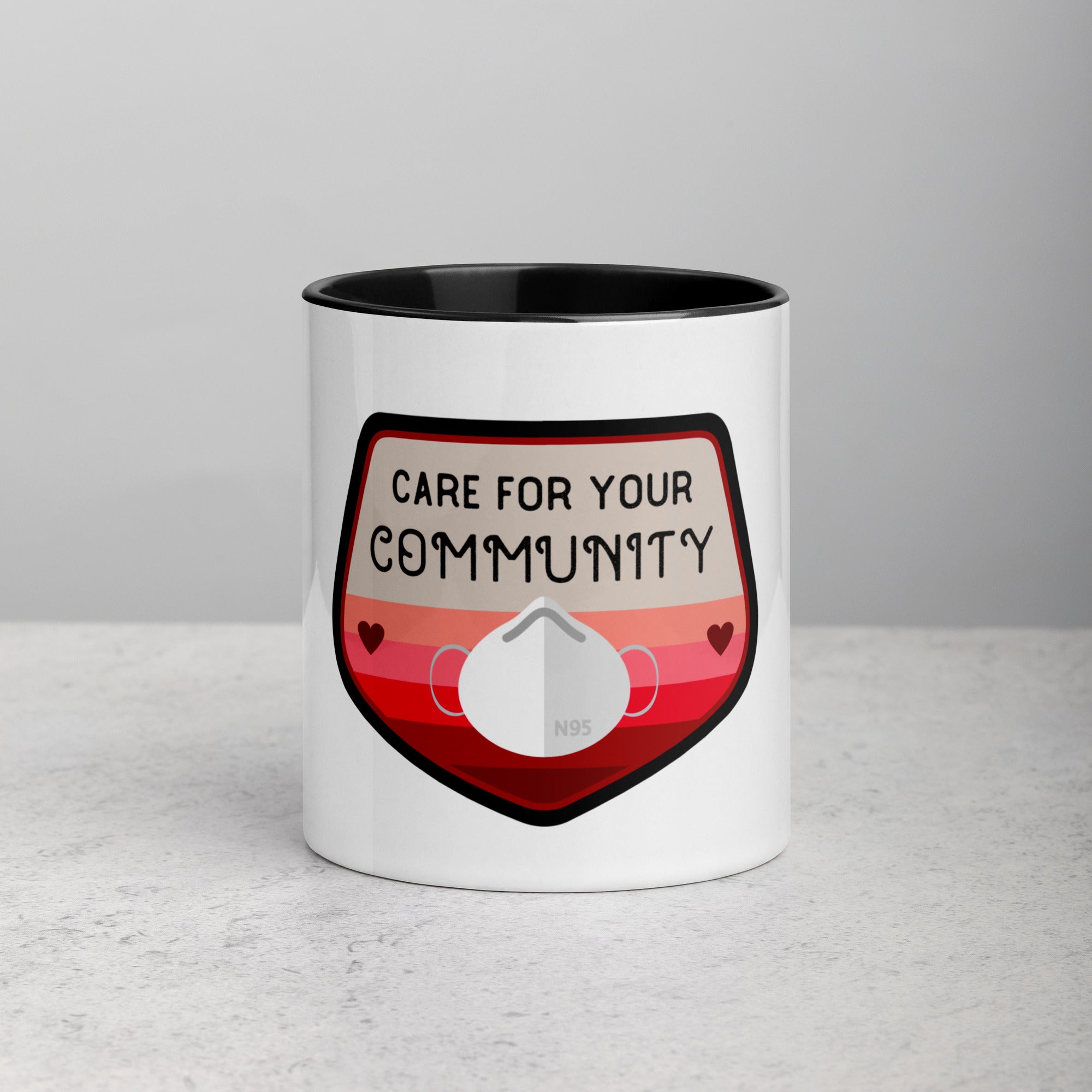 front facing white mug with black interior and handle. Mug has image with n95 mask and Care for your community